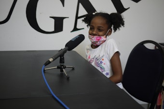caption: Fifth-grader Jadorie Green-Fisher talks with family support worker Gerald Donaldson about some big moments of 2020. 
