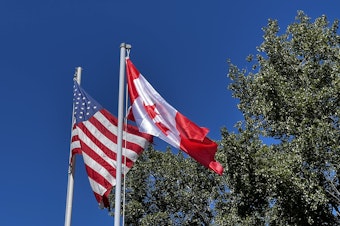 caption: On July 4, Point Roberts puts up a Canadian flag at the local community center. The streets fill with Canadians, who may have also been in town for Canada Day that same week. 