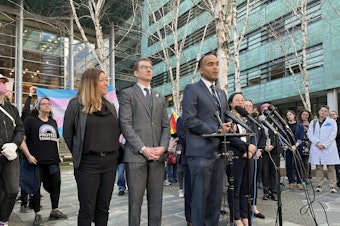 caption: Washington State Attorney General Nick Brown holds a press conference outside of the U.S. District Court for the Western District of Washington on Friday, Feb. 28, 2025.