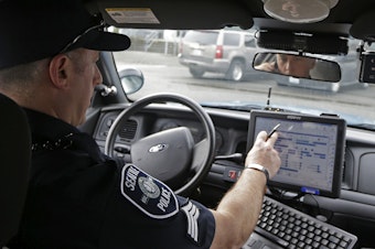 caption: In this photo taken March 2, 2016, Seattle Police officer Eric Pisconski, of SPD's crisis response unit, responds to a call in Seattle. 