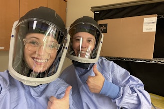 caption: Victoria Price (left) poses for a photo with a co-worker.