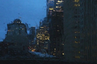 caption: A view of downtown Seattle is shown through a rain covered windshield on Tuesday, Dec. 5, 2023. An atmospheric river has hit Western Washington with winds, heavy rain, and possible flooding. 
