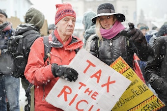 caption: A demonstration at the annual meeting of the World Economic Forum in Davos, Switzerland, in 2023. A perennial Davos topic is how to improve the lives of the world's poor.