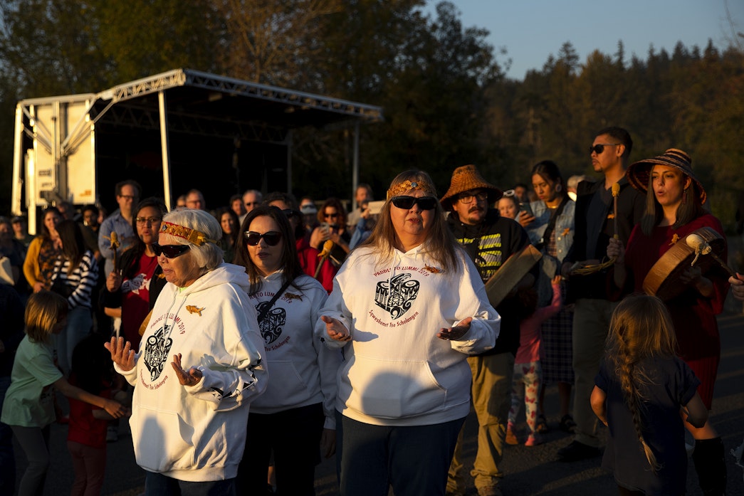 caption: From left, Snoqualmie tribal elder Linda Sweet Baxter, tribal member McKenna Sweet Dorman, and tribal elder Lois Sweet Dorman sing before the release of endangered juvenile kokanee salmon into Lake Sammamish, on Oct. 12, 2022.