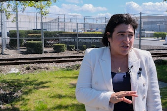 caption: U.S. Rep. Emily Randall, a Washington Democrat, speaks to press in front of the Northwest ICE Processing Center in Tacoma. This is her first time visiting the facility. 