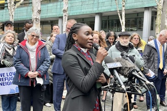 caption: Rev. Emillie Binja celebrate's a judge's ruling against President Donald Trump's refugee ban outside of the U.S. District Court for the Western District of Washington on Tuesday, Feb. 25, 2025. Binja came to the U.S. as a refugee after fleeing the Democratic Republic of Congo at age 8.