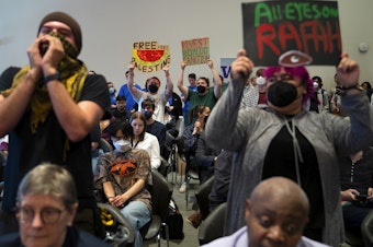 caption: Students cheer for a fellow student who spoke to the UW Board of Regent during public comment, imploring them to divest from Israel and to cut ties with Boeing, at the UW Board of Regents meeting on Thursday, May 9, 2024, on campus in Seattle. 