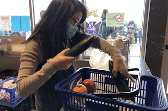 caption: Northwest Harvest staff member Laurie Eckhardt bags produce at the organization's community market in SODO. 