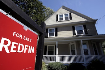 caption: In this July 9, 2018, file photo, a for sale sign stands outside a pre-existing home, in Walpole, Mass.