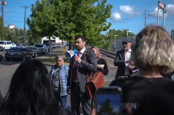 caption: Attorney Larkin VanDerhoef speaks to a gathered crowd outside the Northwest ICE Processing Center in Tacoma. Vanderhoef represents Alfredo "Lelo" Juarez Zeferino, a farmworker union organizer, who is being held in he center and who was denied bond this week.