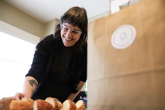 caption: Carrine Fisher gets the 13 pieces of bagels ready to try as part of Bagel Quest on Feb. 17, 2024.