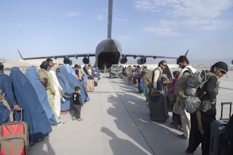caption: In this image provided by the U.S. Air Force, U.S. Air Force loadmasters and pilots assigned to the 816th Expeditionary Airlift Squadron, load people being evacuated from Afghanistan onto a U.S. Air Force C-17 Globemaster III at Hamid Karzai International Airport in Kabul, Afghanistan, Tuesday, Aug. 24, 2021.