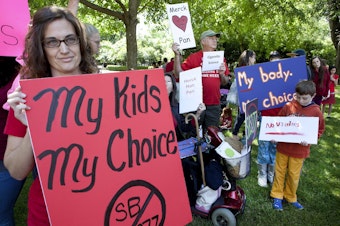 caption: Nikki Craven at a rally in California in 2015, opposing legislation that would require immunizations, an effort to combat outbreaks of measles and whooping cough. 