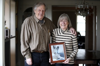 caption: Leonard and Pam Johnson hold a photo of their dog, Django, who passed away last week. Leonard "Ned" Johnson is one of the people identified by the Social Security Administration as dead, even though he is alive and well and living in Seattle.  