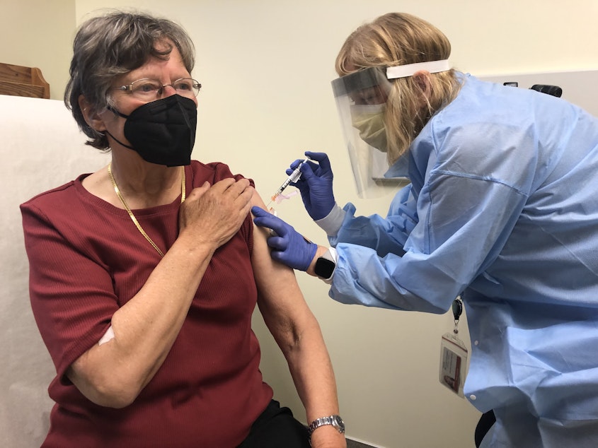 caption: As part of a phase 1 clinical trial of a variant-specific COVID-19 vaccine developed by Moderna, pharmacist Sue Lasicka gives a shot of the vaccine candidate to volunteer Suzanne Uvelli-Spencer, MD, on April 1, 2021, at Kaiser Permanente Washington Health Research Institute in Seattle.