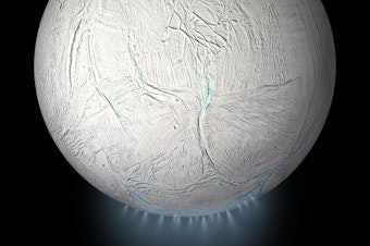 caption: This illustration shows Saturn's icy moon Enceladus with a plume of ice particles, water vapor, and organic molecules that sprays from fractures in the moon's south polar region.