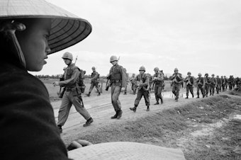 caption: Marines marching in Danang. March 15, 1965.