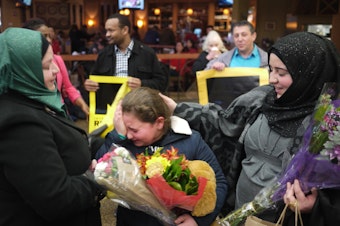 caption: Syrian refugee Alaa Al Halabi, 11, is overcome with emotion as her siblings arrive in Seattle on Februray 9, 2017. The siblings were delayed by the Trump Administration's initial travel ban.