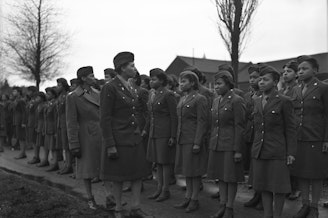 caption: Somewhere in England, Maj. Charity E. Adams, Columbia, S.C., and Capt. Abbie N. Campbell, Tuskegee Institute, Tuskegee, Ala., inspect the first contingent of Black members of the Women's Army Corps assigned to overseas service.