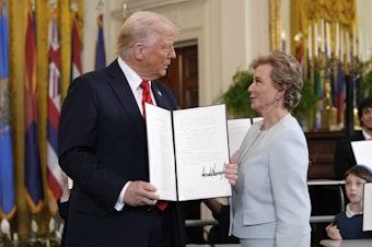 caption: President Donald Trump holds up a signed executive order alongside Secretary of Education Linda McMahon in the East Room of the White House in Washington, Thursday, March 20, 2025. 