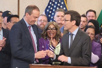 caption: Gov. Bob Ferguson giving an official pen to state Sen. Marcus Riccelli on May 19, 2025.