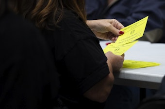 caption: Union members count votes from striking Boeing machinists on whether to accept or reject the latest contract offer from Boeing on Wednesday, October 23, 2024, at IAM Hall in Seattle. 