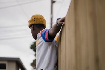 caption: Getahun balances on a garden bed on Sunday, March 13, 2022, in Seattle, Washington. Getahun, now 13, was adopted as an infant from Ethiopia by a Washington state couple. His former adoptive mother, Kyle Wohlers, was criminally charged for abusing him in 2021. The case was dropped a year later, after a prosecutor determined that Getahun was not mentally well enough to testify during a trial. 