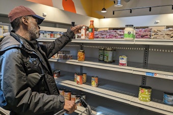 caption: C'zar Carter-Alexander shops at the Ballard Food Bank on Monday, April 3, 2023.
