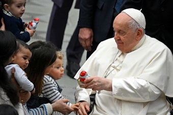 caption: Pope Francis distributes sweets to children during the weekly general audience in Paul VI hall at the Vatican on Jan. 3.